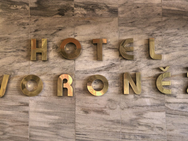 Hotel Voroněž - nerezový nápis v hale hotelu - 02
